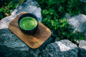 Fotografía de una taza de té verde humeante con notas frescas y herbales.