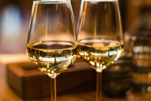 La imagen muestra una copa de vino blanco con un color brillante y aroma fresco y frutal.